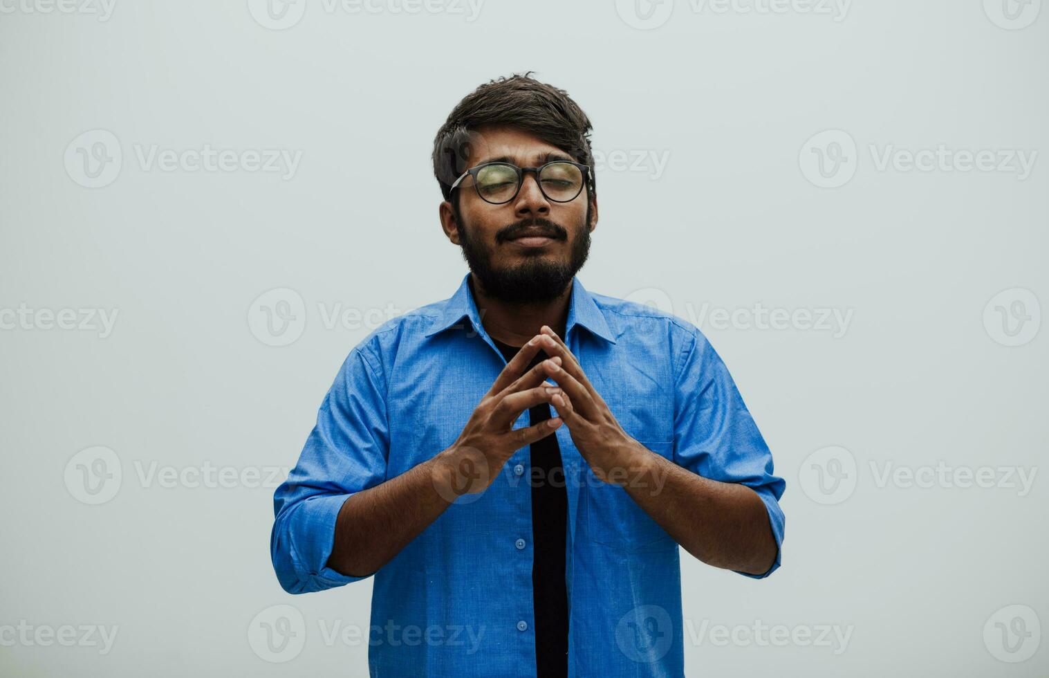 Indian young man Studen showing his concentration and focus with symbolic gestures while standing in front of the school blackboard photo