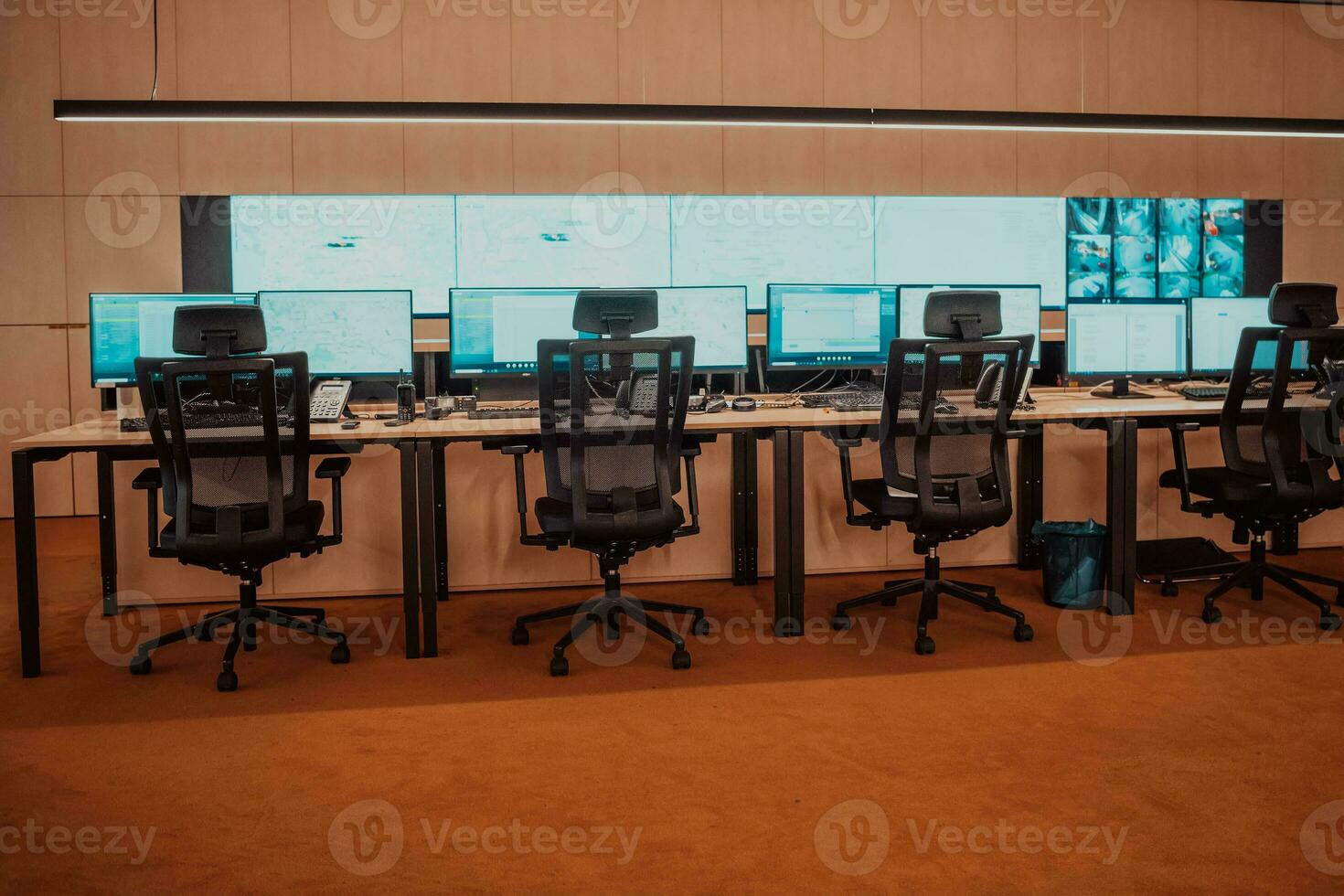 Empty interior of big modern security system control room, workstation with multiple displays, monitoring room with at security data center Empty office, desk, and chairs at a main CCTV security data photo