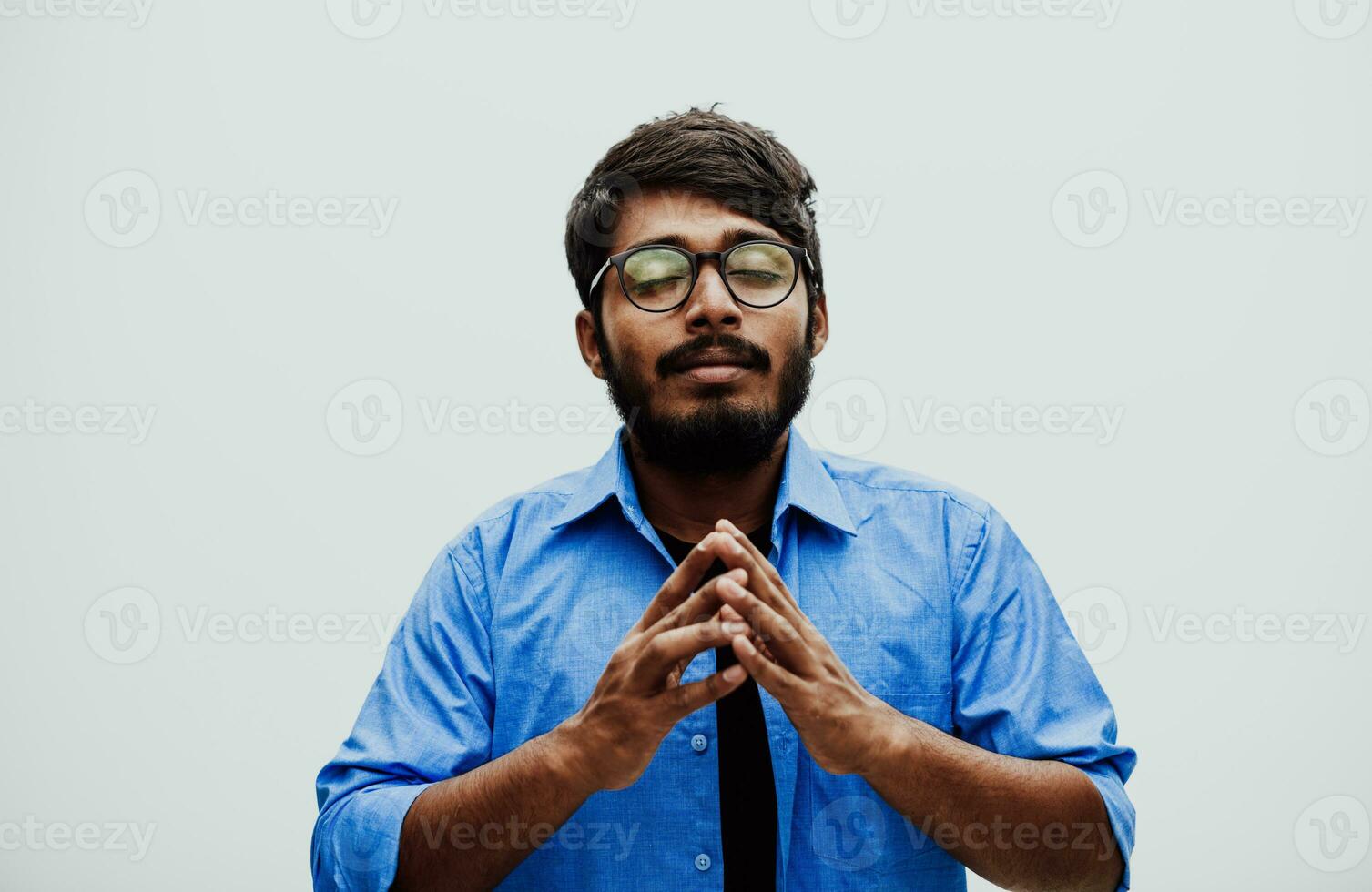 Indian young man Studen showing his concentration and focus with symbolic gestures while standing in front of the school blackboard photo