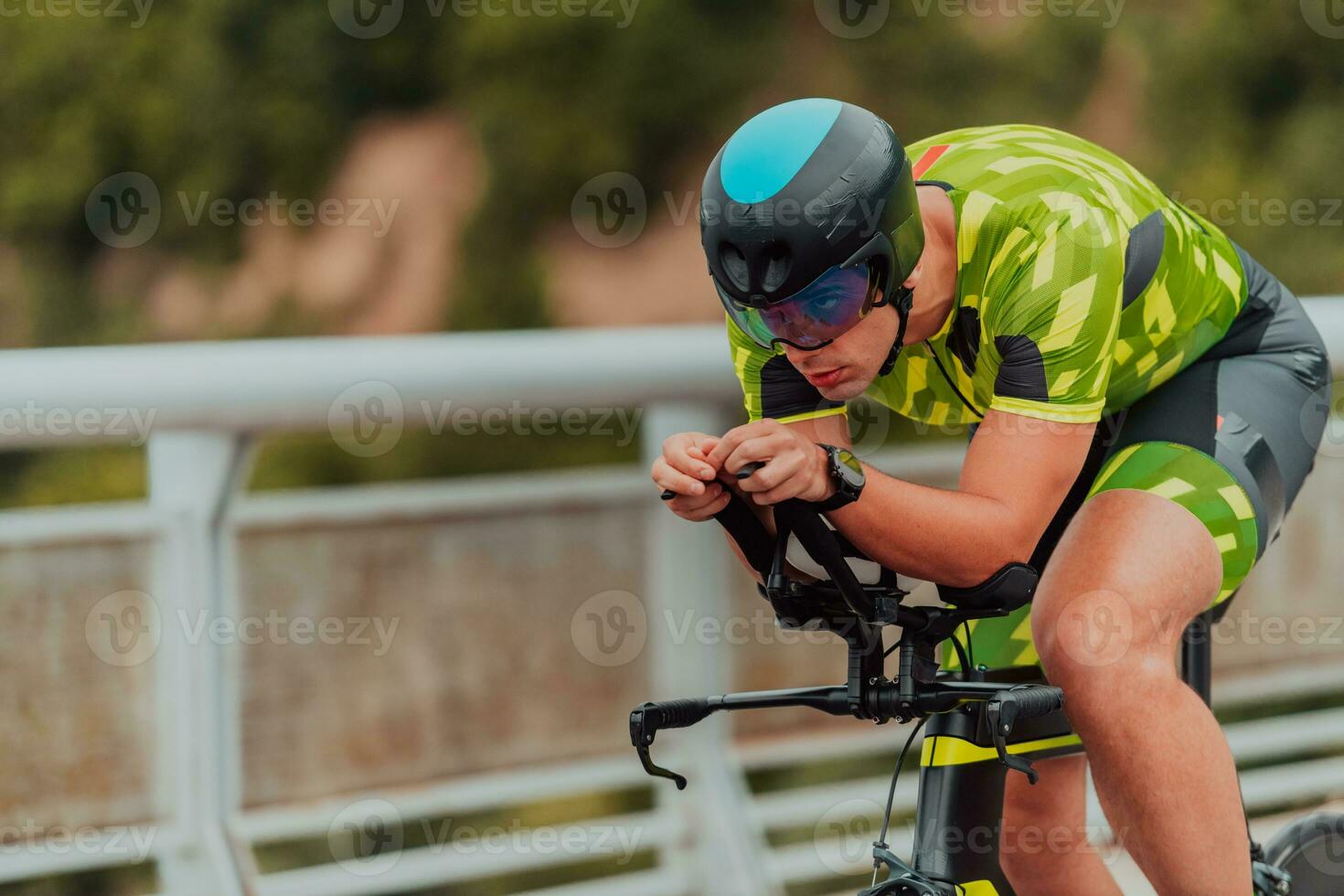 lleno longitud retrato de un activo triatleta en ropa de deporte y con un protector casco montando un bicicleta. selectivo atención foto