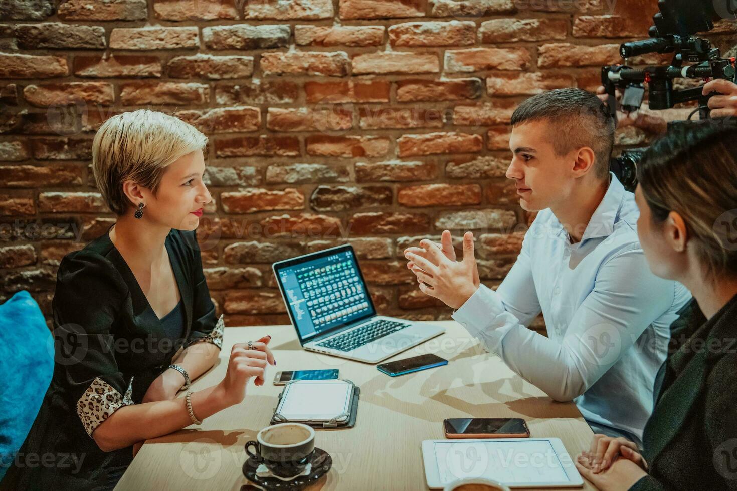 Happy businesspeople smiling cheerfully during a meeting in a coffee shop. Group of successful business professionals working as a team in a multicultural workplace. photo