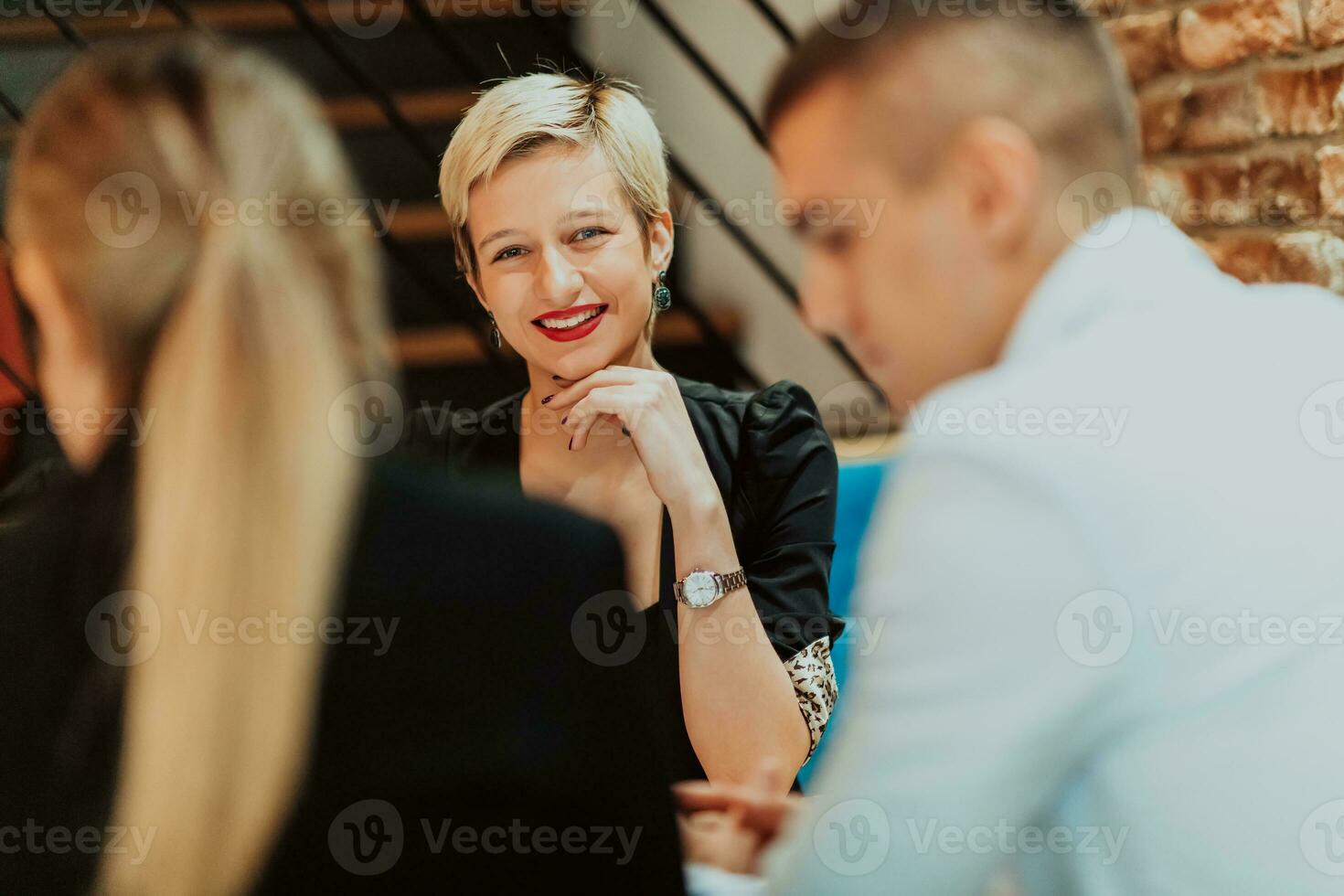 Happy businesspeople smiling cheerfully during a meeting in a coffee shop. Group of successful business professionals working as a team in a multicultural workplace. photo