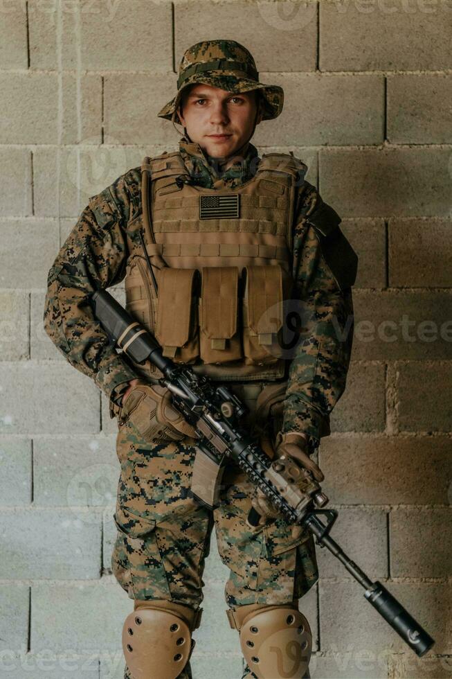 un soldado en uniforme soportes en frente de un Roca pared en lleno guerra engranaje preparando para batalla foto