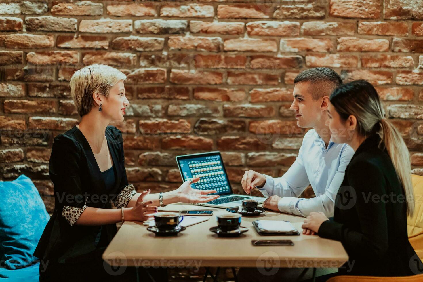 Happy businesspeople smiling cheerfully during a meeting in a coffee shop. Group of successful business professionals working as a team in a multicultural workplace. photo