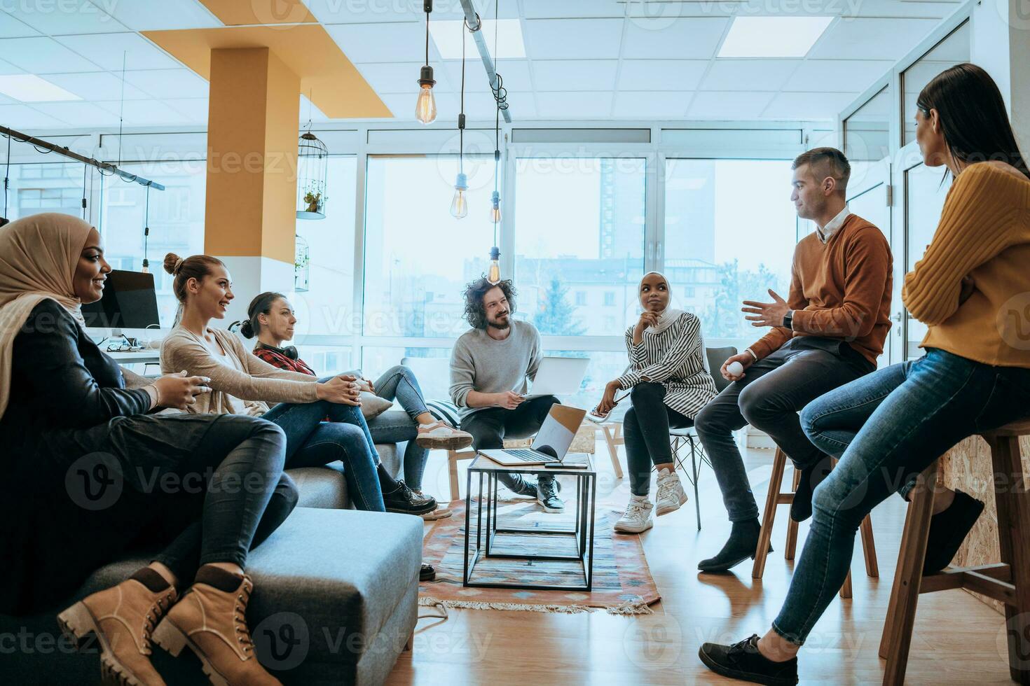 Young designer giving some new ideas about project to his partners in conference room. Business people discussing over new business project in office. photo