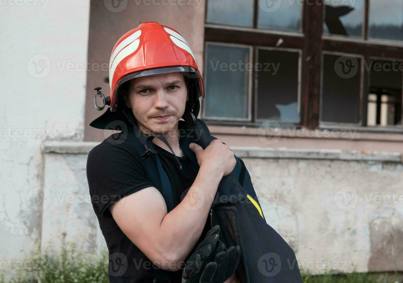 bombero con uniforme y casco estar en frente de eléctrico cable en un techo parte superior foto