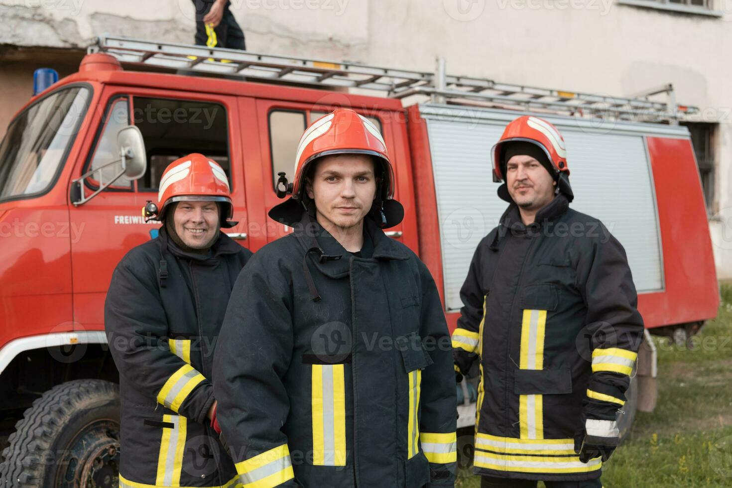 Group of fire fighters standing confident after a well done rescue operation. Firemen ready for emergency service. photo