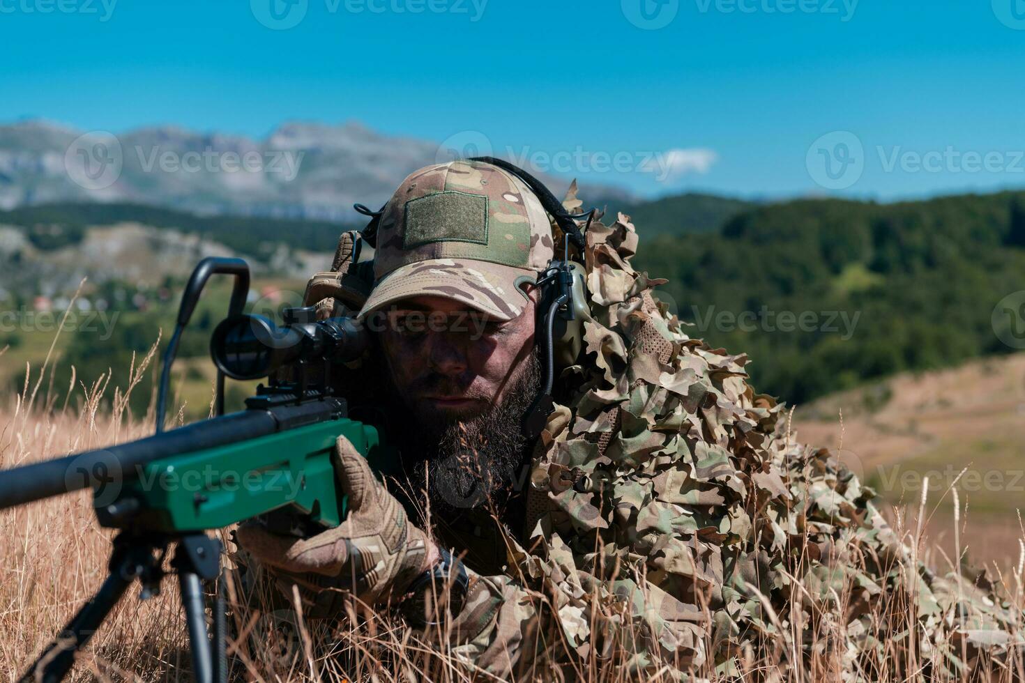 Army soldier holding sniper rifle with scope and aiming in forest. War, army, technology and people concept photo
