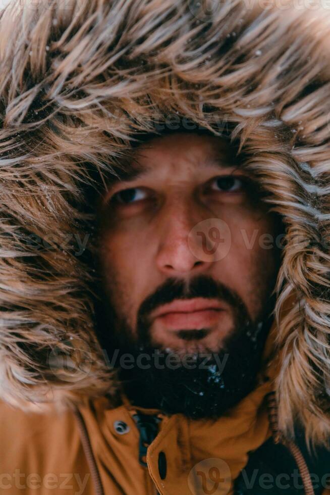 Headshot photo of a man in a cold snowy area wearing a thick brown winter jacket and gloves. Life in cold regions of the country.