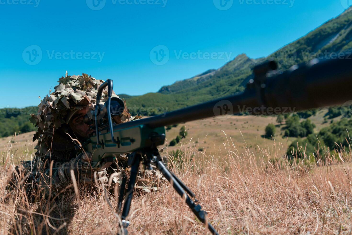 Army soldier holding sniper rifle with scope and aiming in forest. War, army, technology and people concept photo