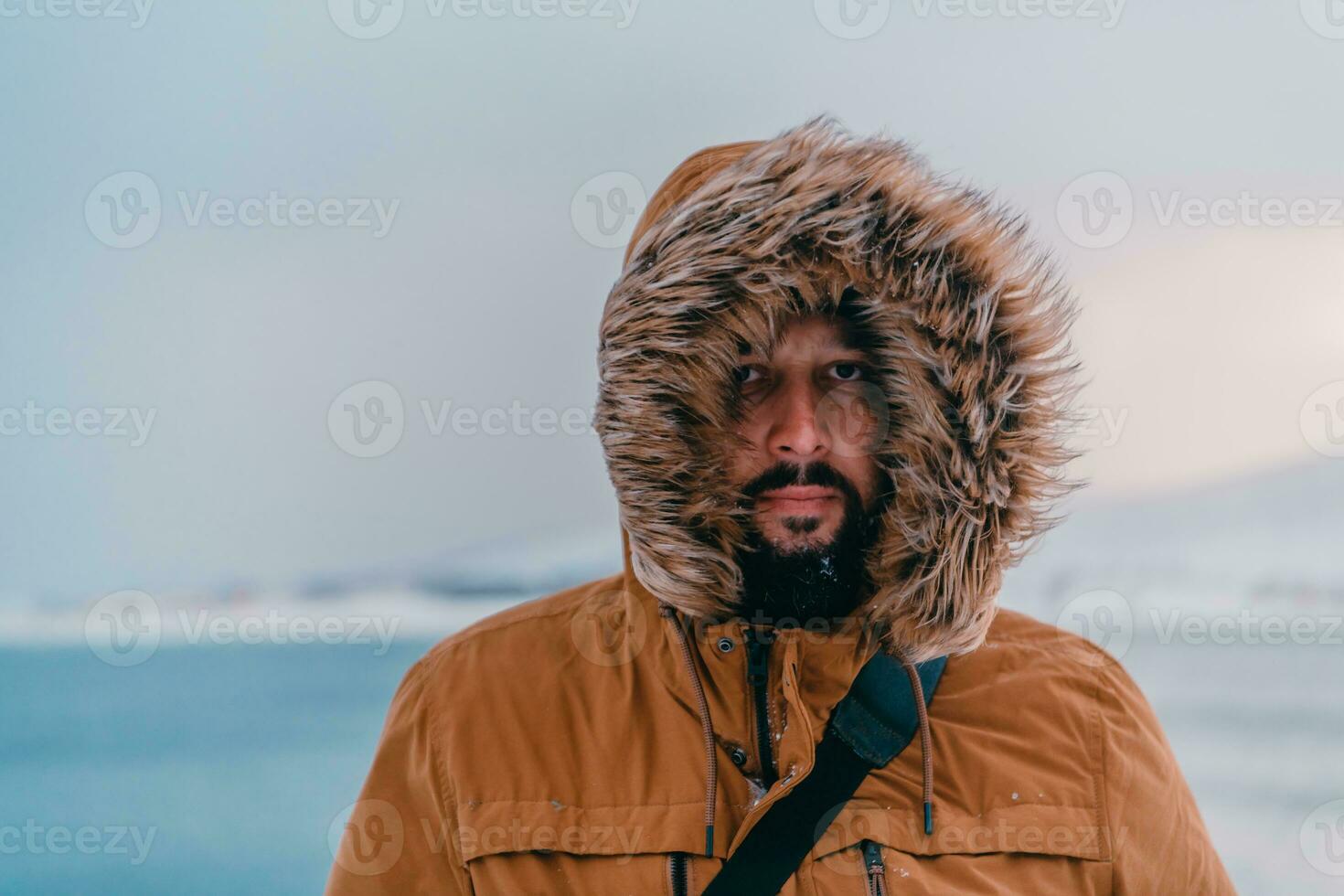 disparo a la cabeza foto de un hombre en un frío Nevado zona vistiendo un grueso marrón invierno chaqueta y guantes. vida en frío regiones de el país.