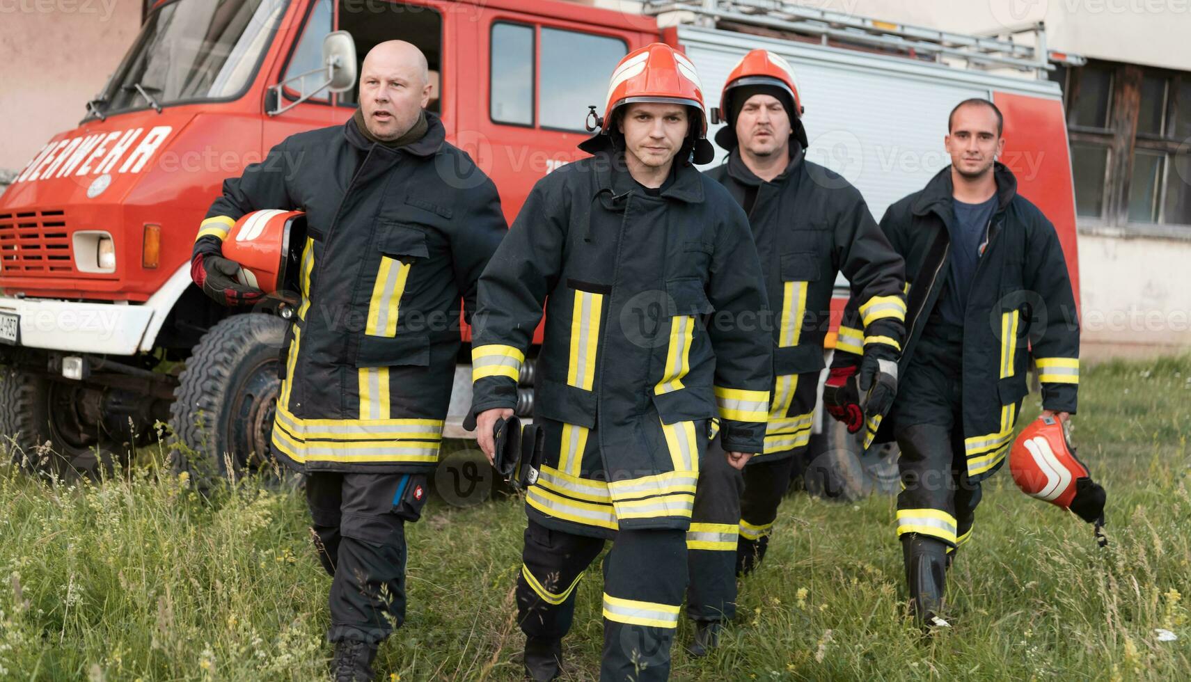 Group of fire fighters standing confident after a well done rescue operation. Firemen ready for emergency service. photo