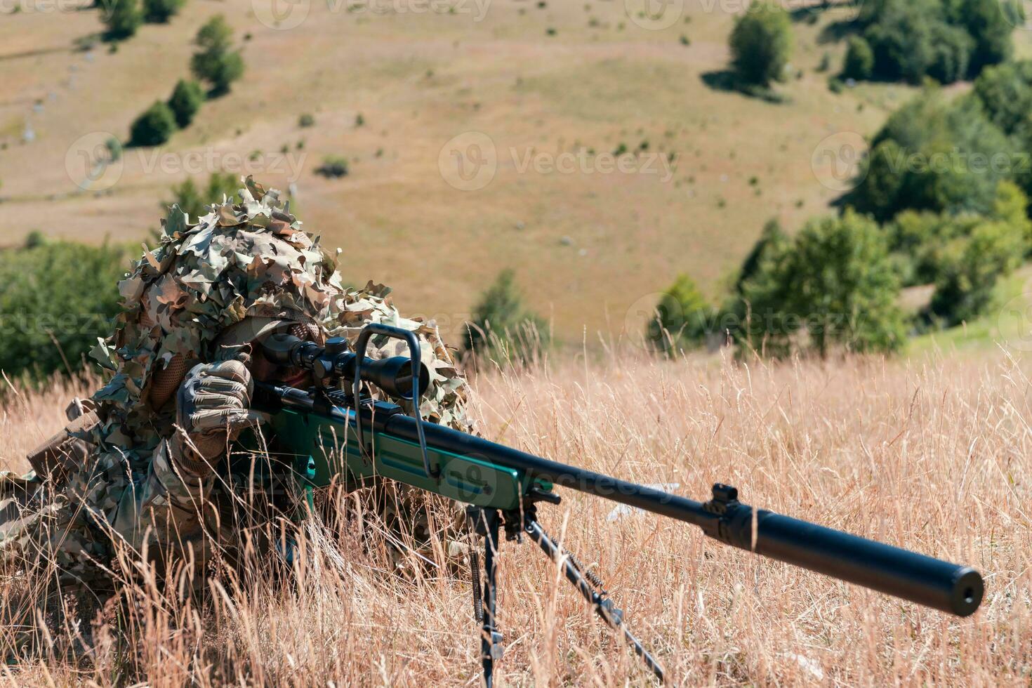 Army soldier holding sniper rifle with scope and aiming in forest. War, army, technology and people concept photo