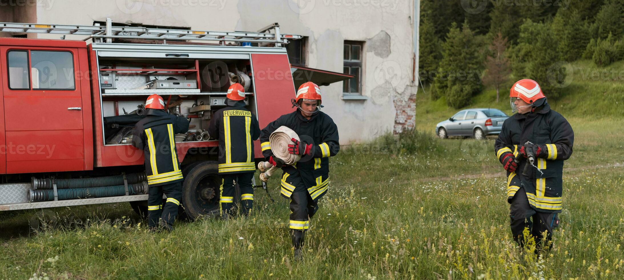 Group of fire fighters standing confident after a well done rescue operation. Firemen ready for emergency service. photo