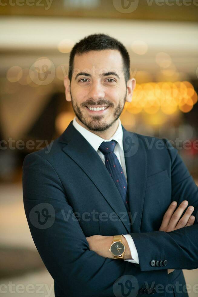 Portrait of a businessman in a suit with his arms crossed in a modern office building photo