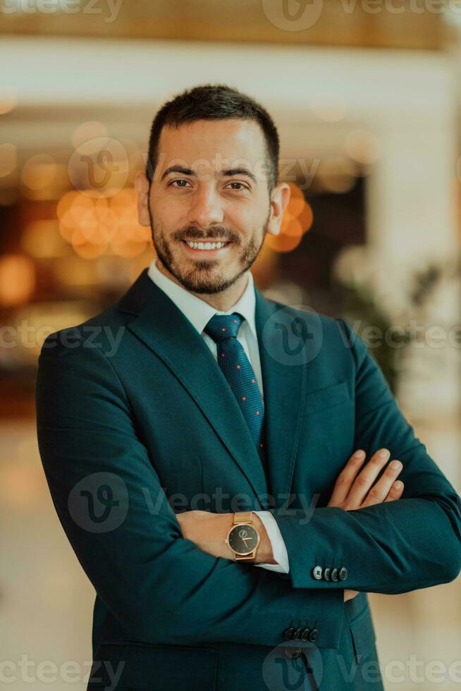 Portrait of a businessman in a suit with his arms crossed in a modern office building photo
