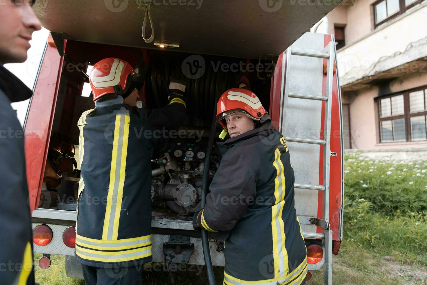 Group of fire fighters standing confident after a well done rescue operation. Firemen ready for emergency service. photo