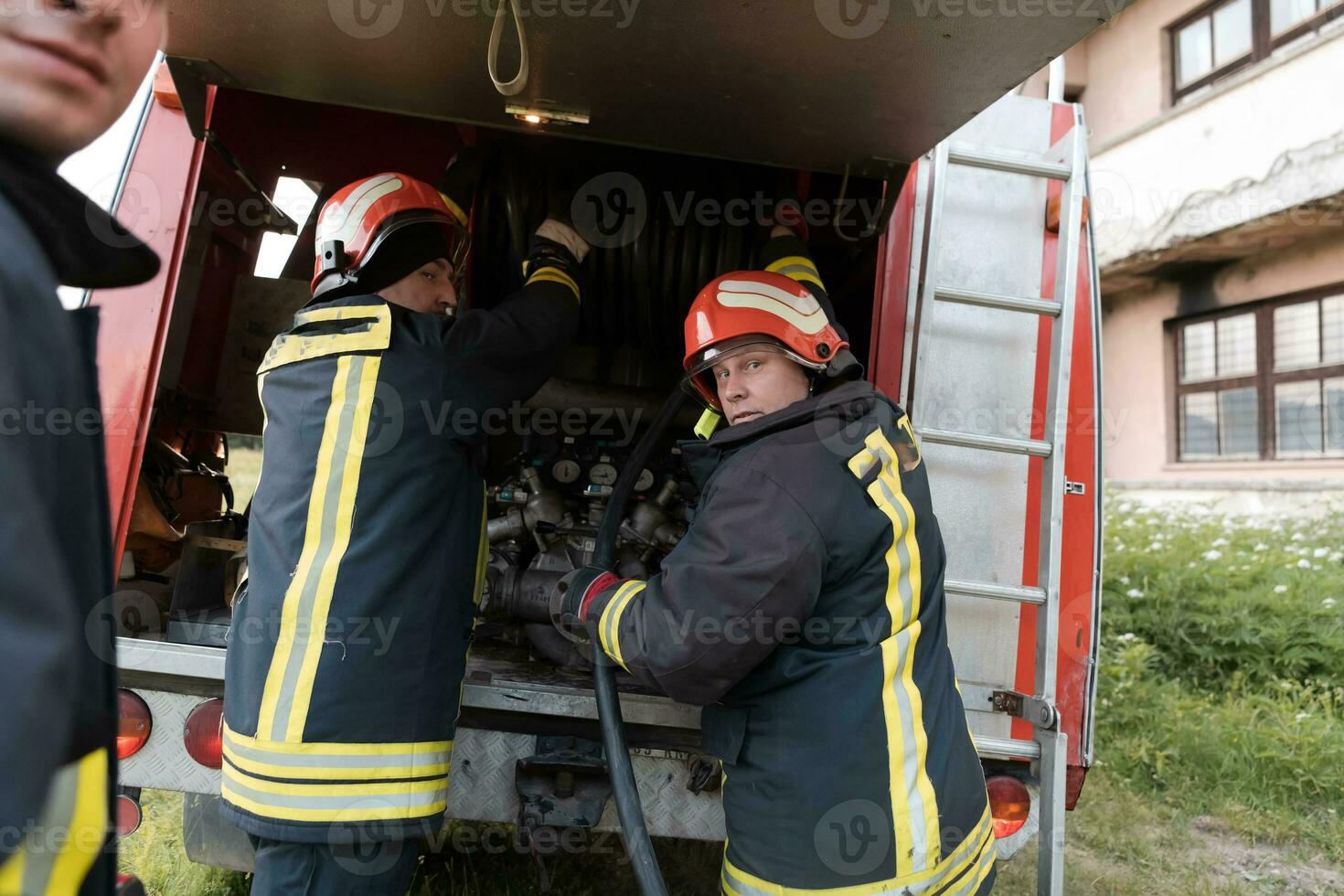 Group of fire fighters standing confident after a well done rescue operation. Firemen ready for emergency service. photo