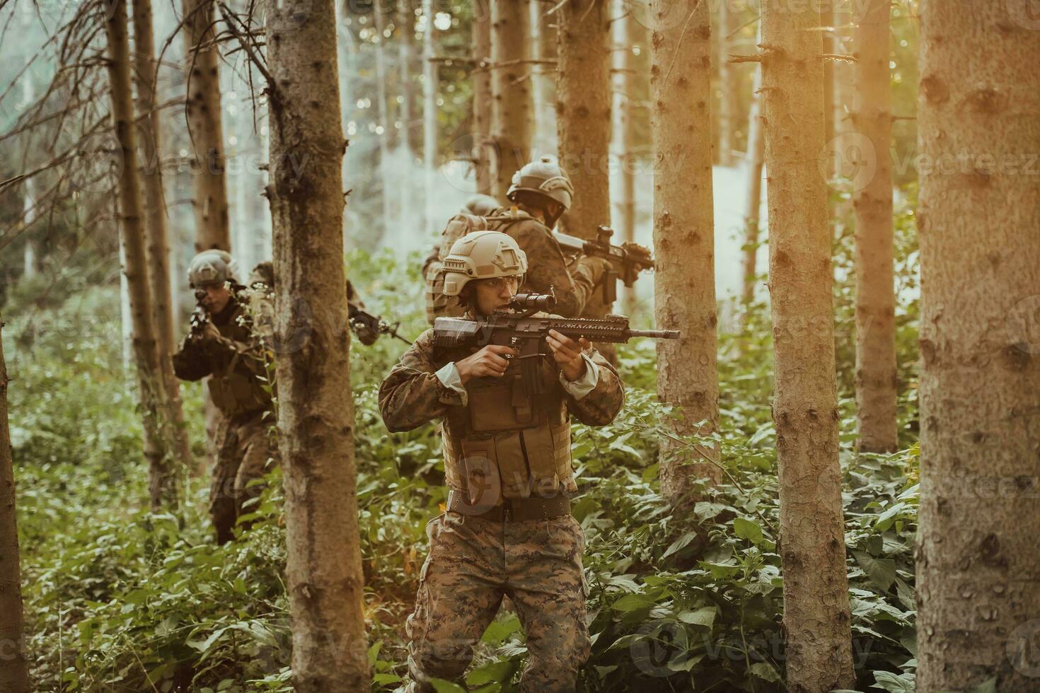 A group of modern warfare soldiers is fighting a war in dangerous remote forest areas. A group of soldiers is fighting on the enemy line with modern weapons. The concept of warfare and military conflicts photo