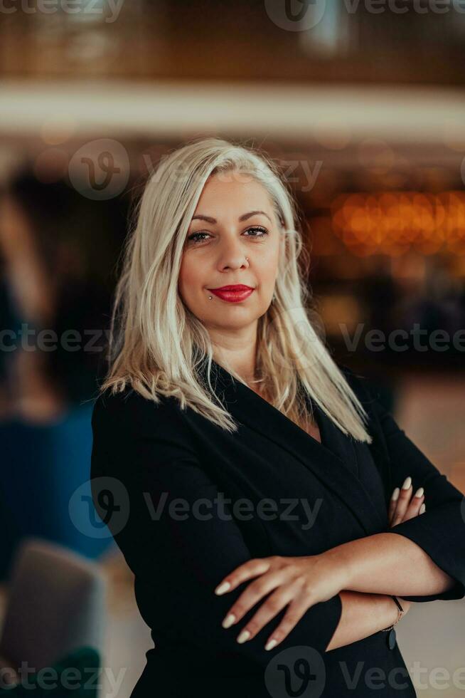 Portrait of business senior woman with crossed arms standing in modern corporation. Selective focus photo