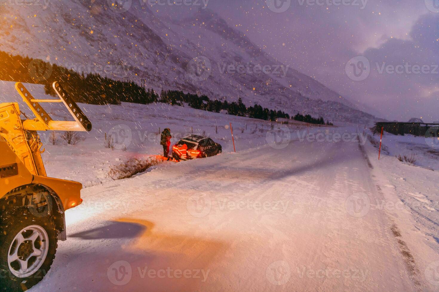 The roadside assistance service pulling the car out of the canal. An incident on a frozen Scandinavian road. photo