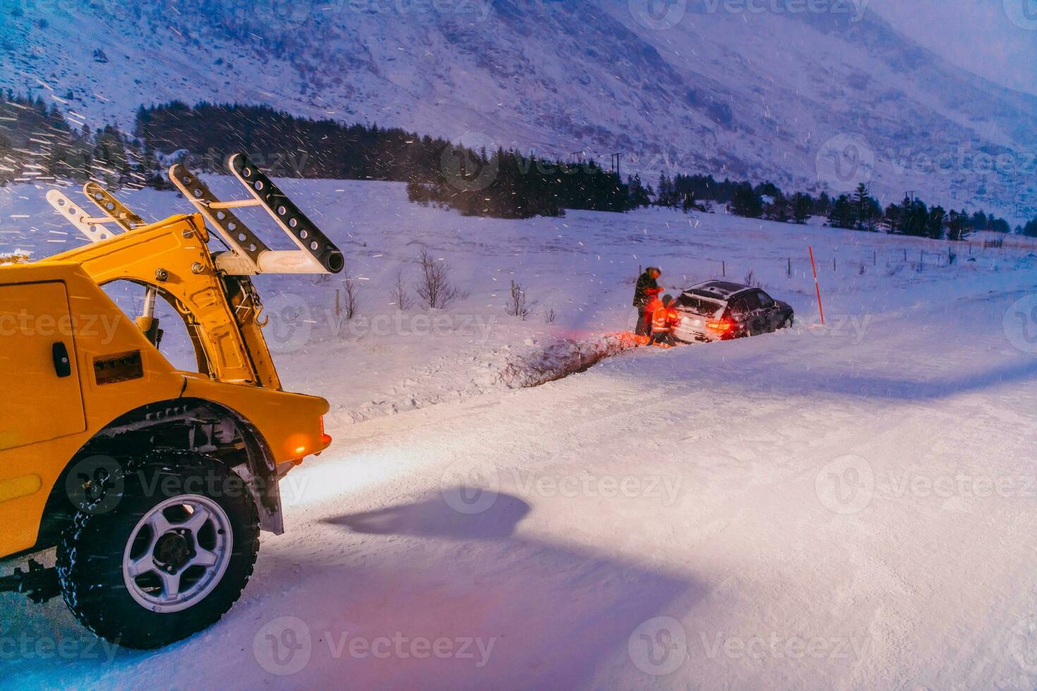 The roadside assistance service pulling the car out of the canal. An incident on a frozen Scandinavian road. photo