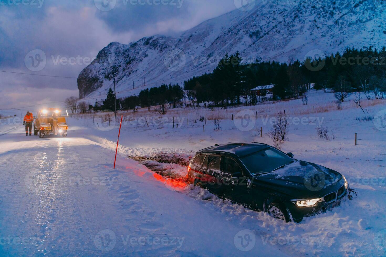 The roadside assistance service pulling the car out of the canal. An incident on a frozen Scandinavian road. photo