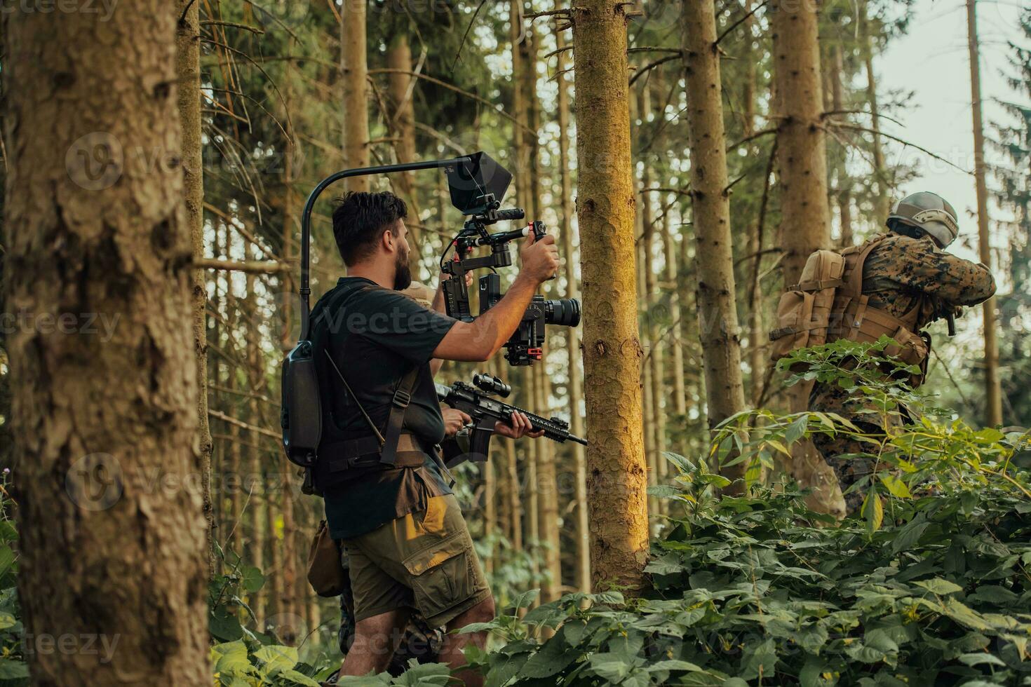 Videographer with Professional Movie Video Camera Gimbal Stabilizing Equipment Taking Action Shoot of Soldiers in Action in Forest photo