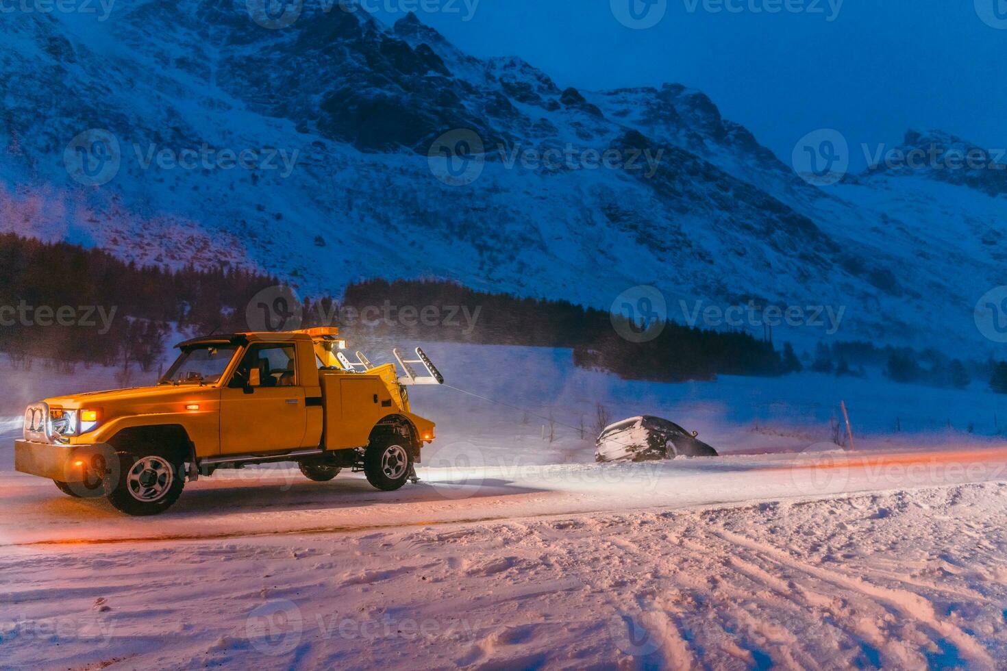 The roadside assistance service pulling the car out of the canal. An incident on a frozen Scandinavian road. photo