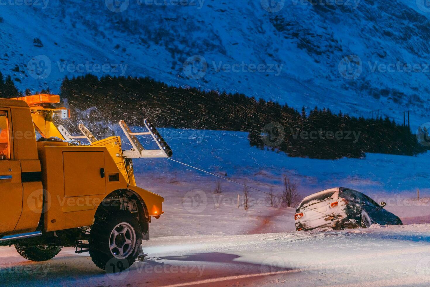 The roadside assistance service pulling the car out of the canal. An incident on a frozen Scandinavian road. photo