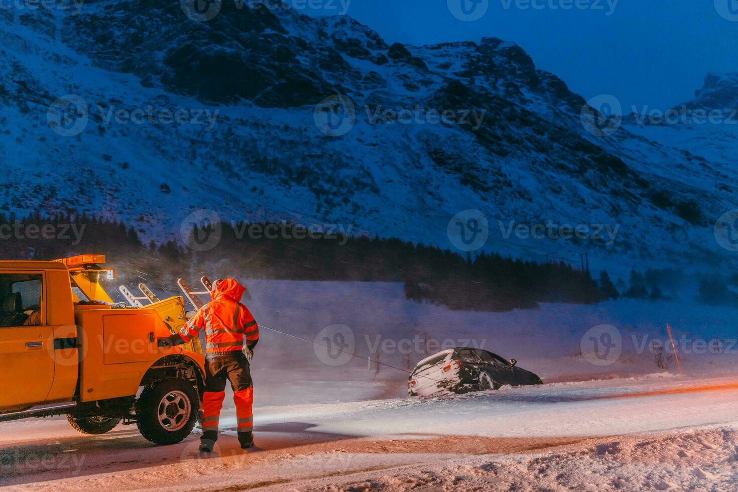 The roadside assistance service pulling the car out of the canal. An incident on a frozen Scandinavian road. photo