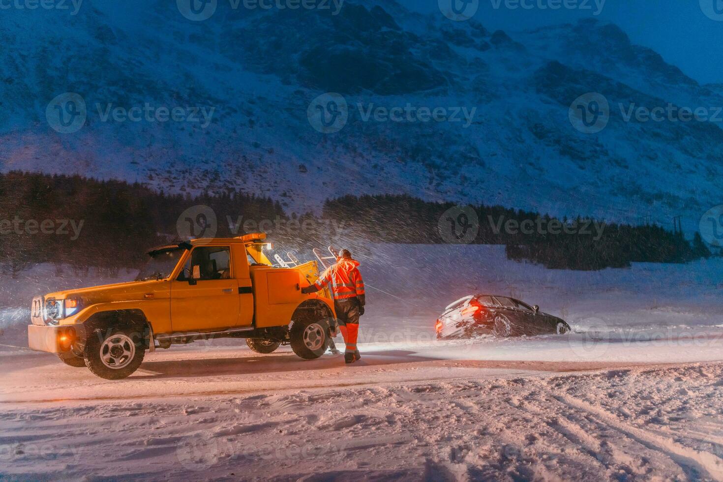 The roadside assistance service pulling the car out of the canal. An incident on a frozen Scandinavian road. photo