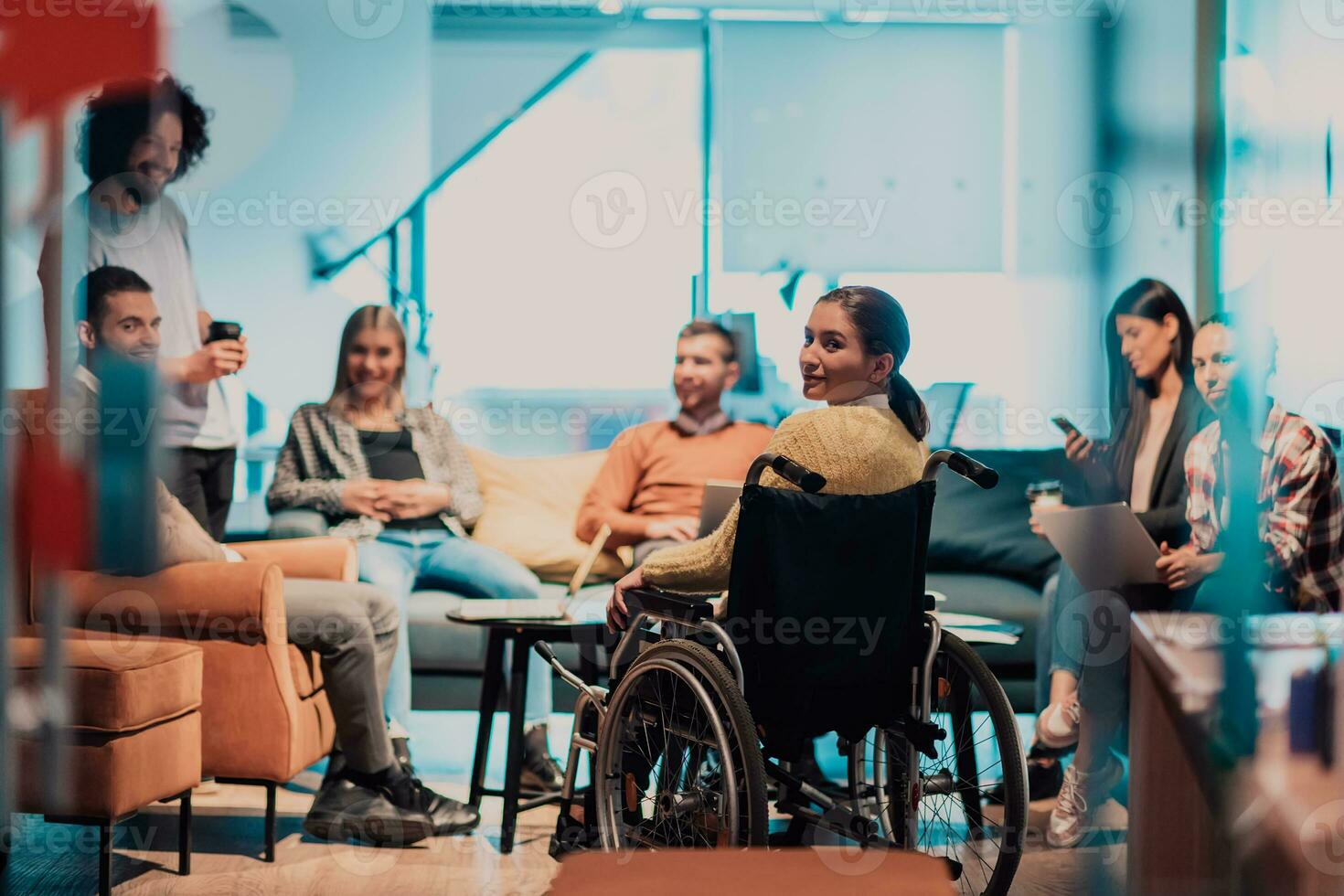 mujer de negocios en silla de ruedas teniendo negocio reunión con equipo a moderno oficina. un grupo de joven autónomos de acuerdo en nuevo en línea negocio proyectos foto