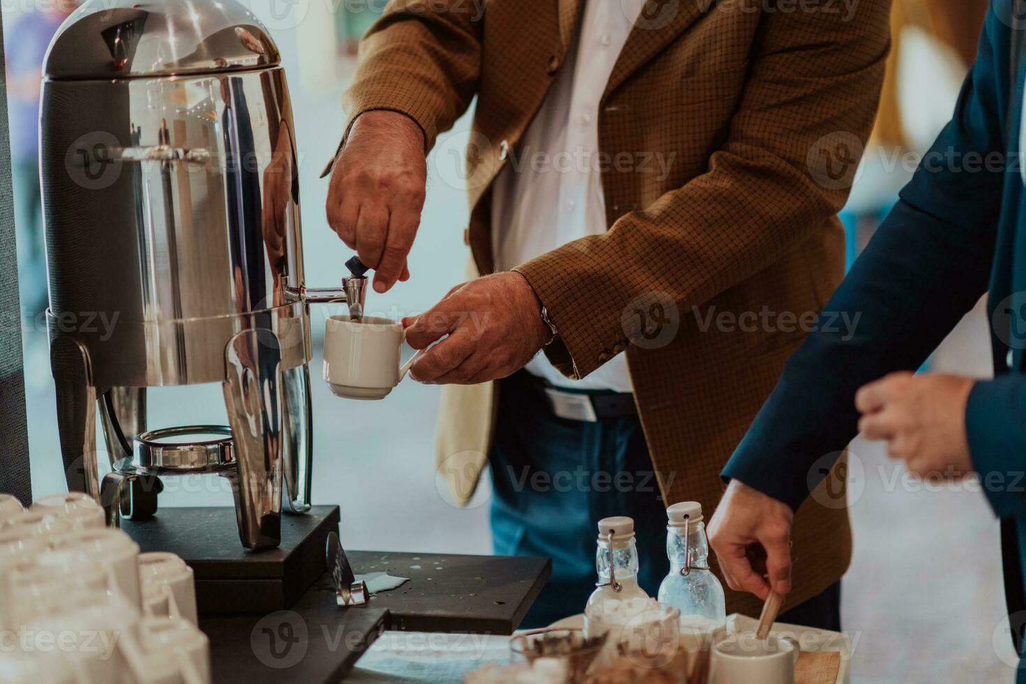 Close-up photo of businessmen serving themselves in a modern hotel during a dinner party. Selective focus