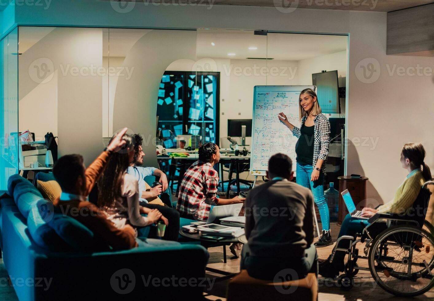 A pregnant businesswoman leads a creative meeting of a diverse business team in a modern coworking photo