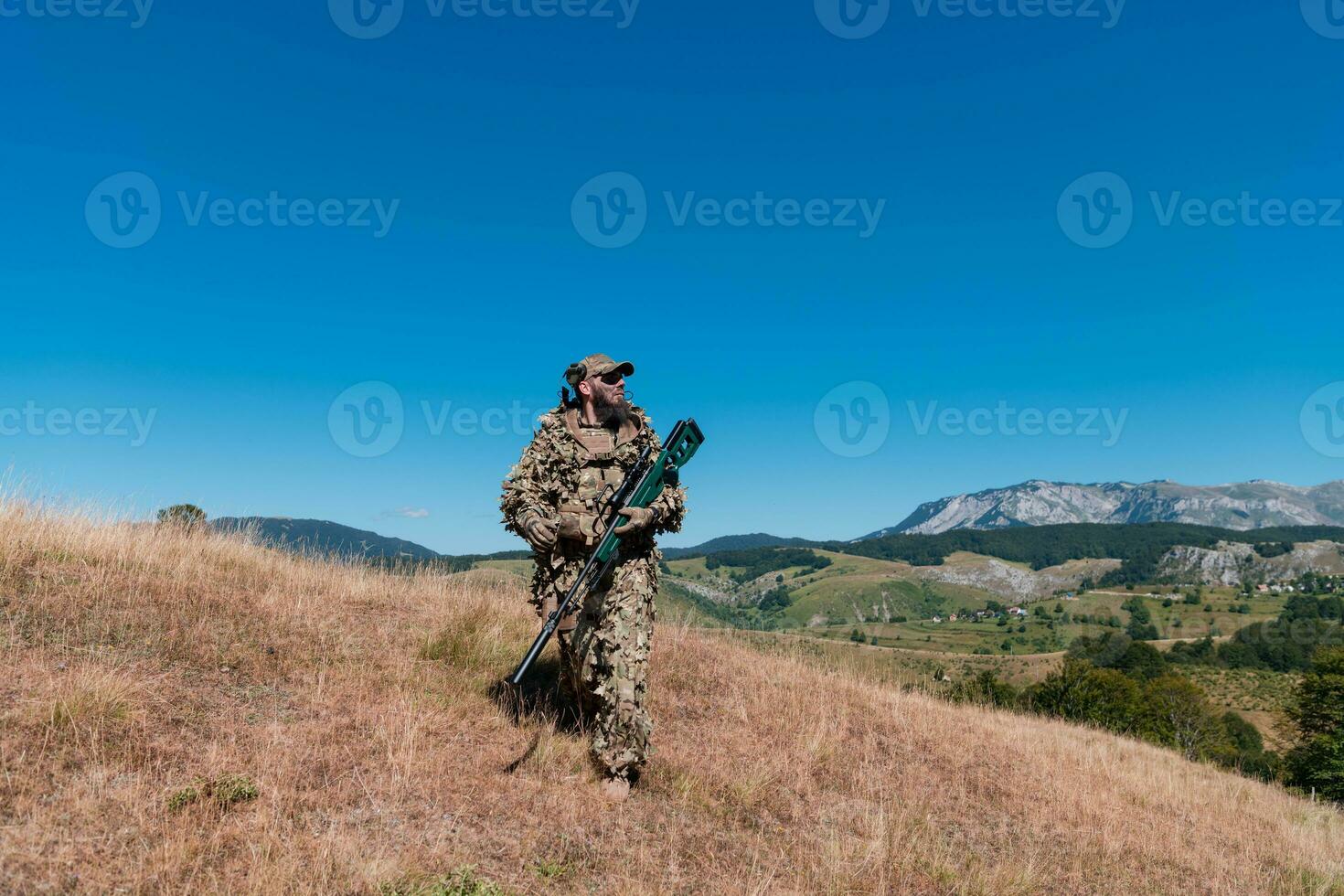 Army soldier holding a sniper rifle with scope and walking in the forest. war, army, technology and people concept. photo