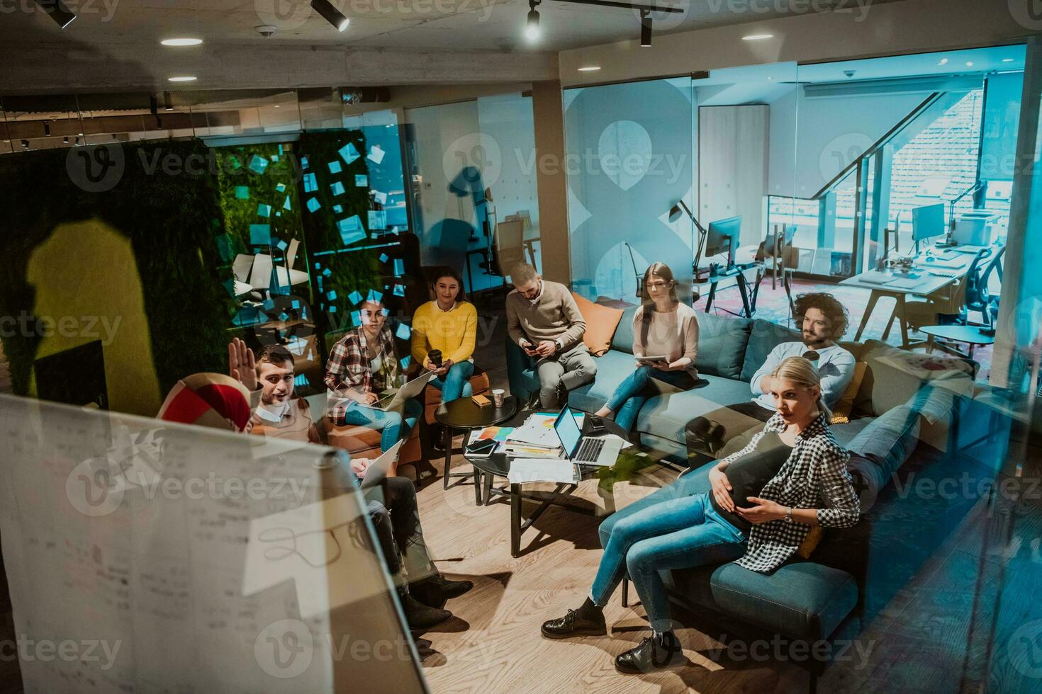 An older Muslim businesswoman presents a project to a young diverse team of people in a modern office photo