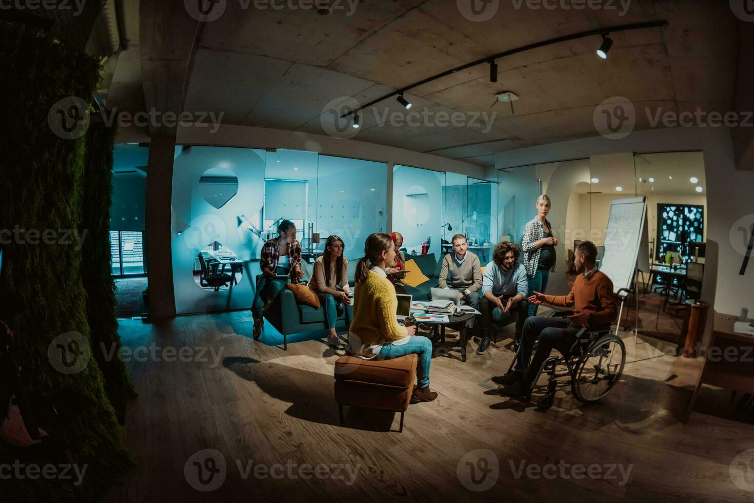 A pregnant businesswoman leads a creative meeting of a diverse business team in a modern coworking photo