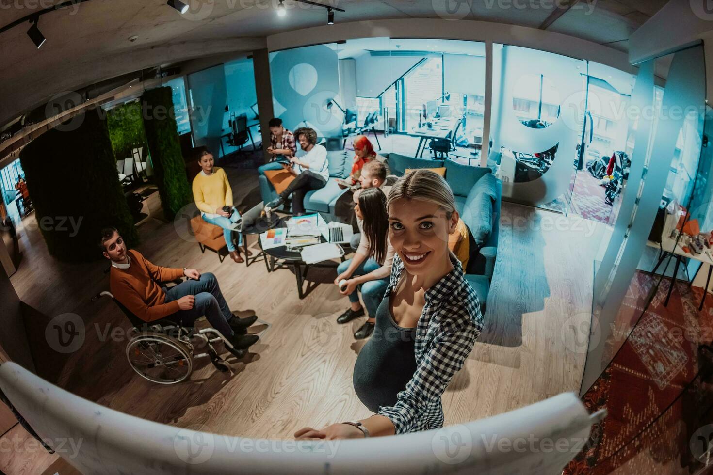 A pregnant businesswoman leads a creative meeting of a diverse business team in a modern coworking photo