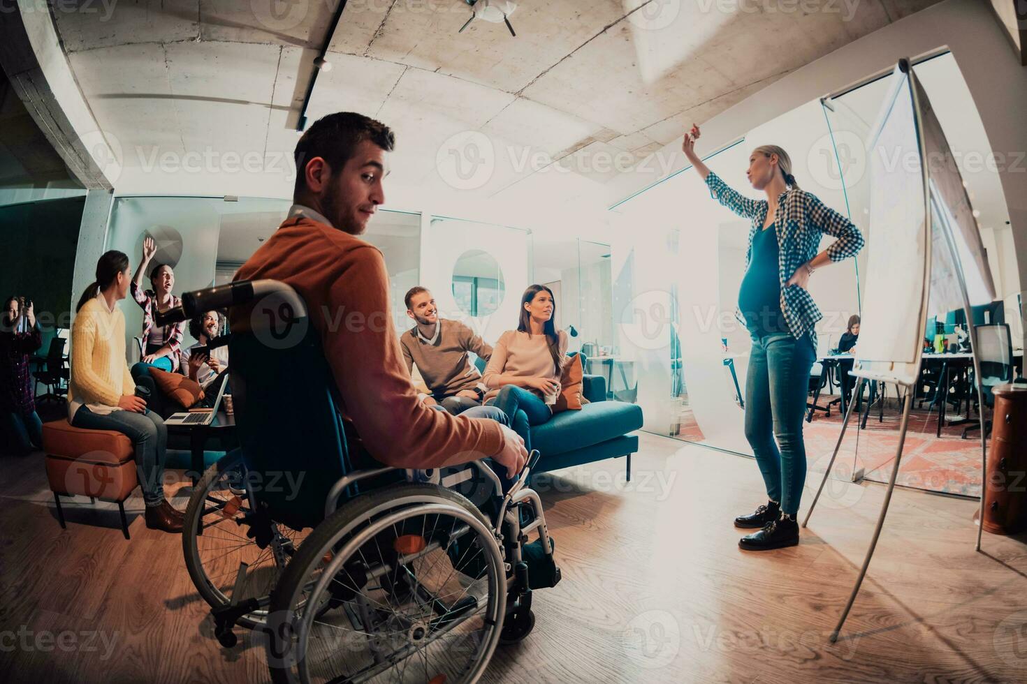 un embarazada mujer de negocios Guías un creativo reunión de un diverso negocio equipo en un moderno trabajo colaborativo foto