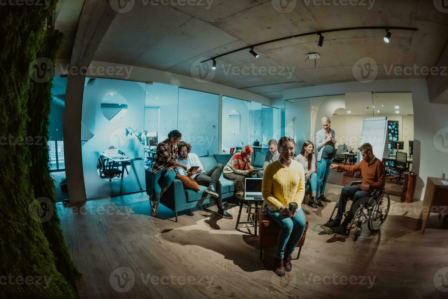 Businesswoman in wheelchair having business meeting with team at modern office. A group of young freelancers agree on new online business projects photo