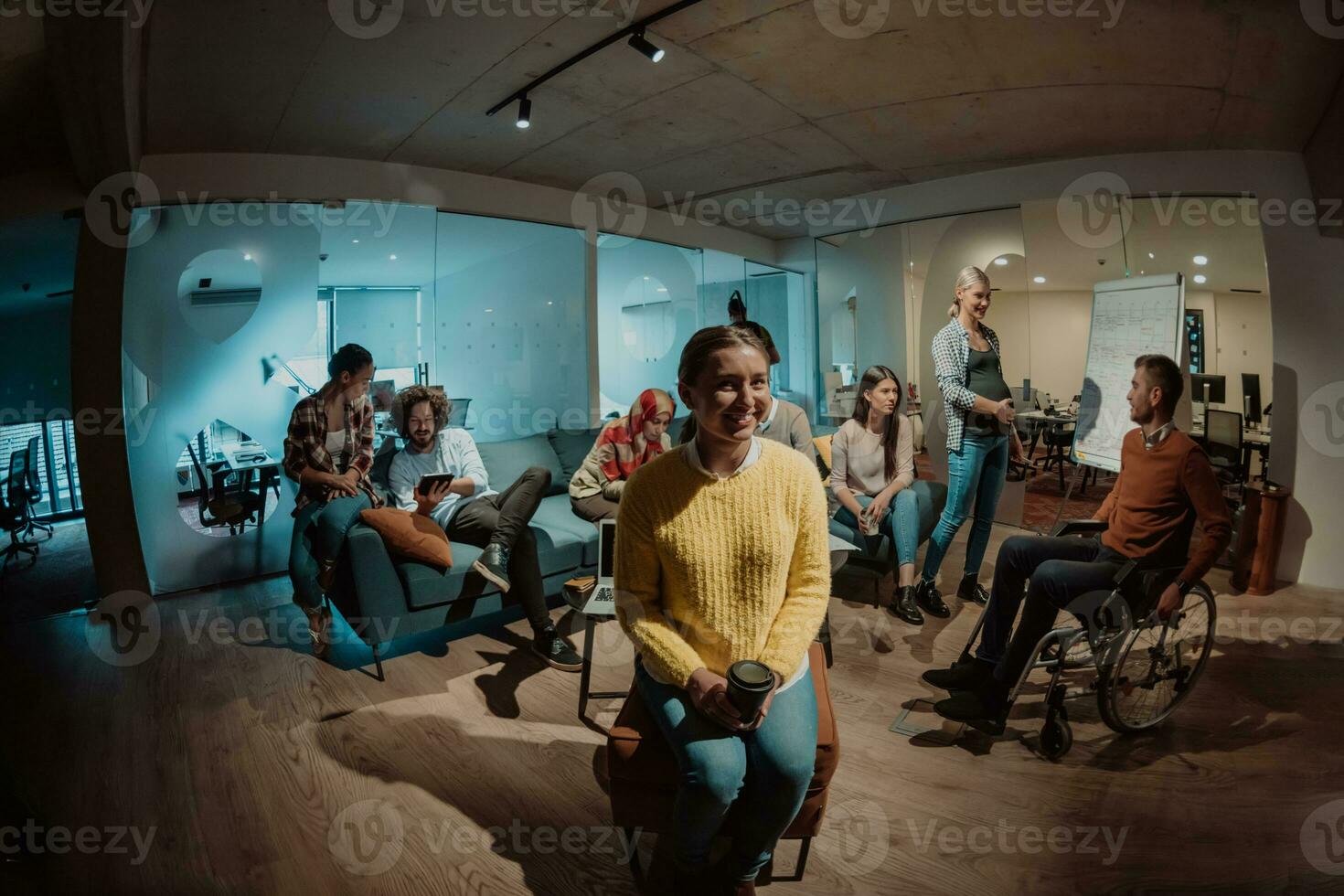 Businesswoman in wheelchair having business meeting with team at modern office. A group of young freelancers agree on new online business projects photo