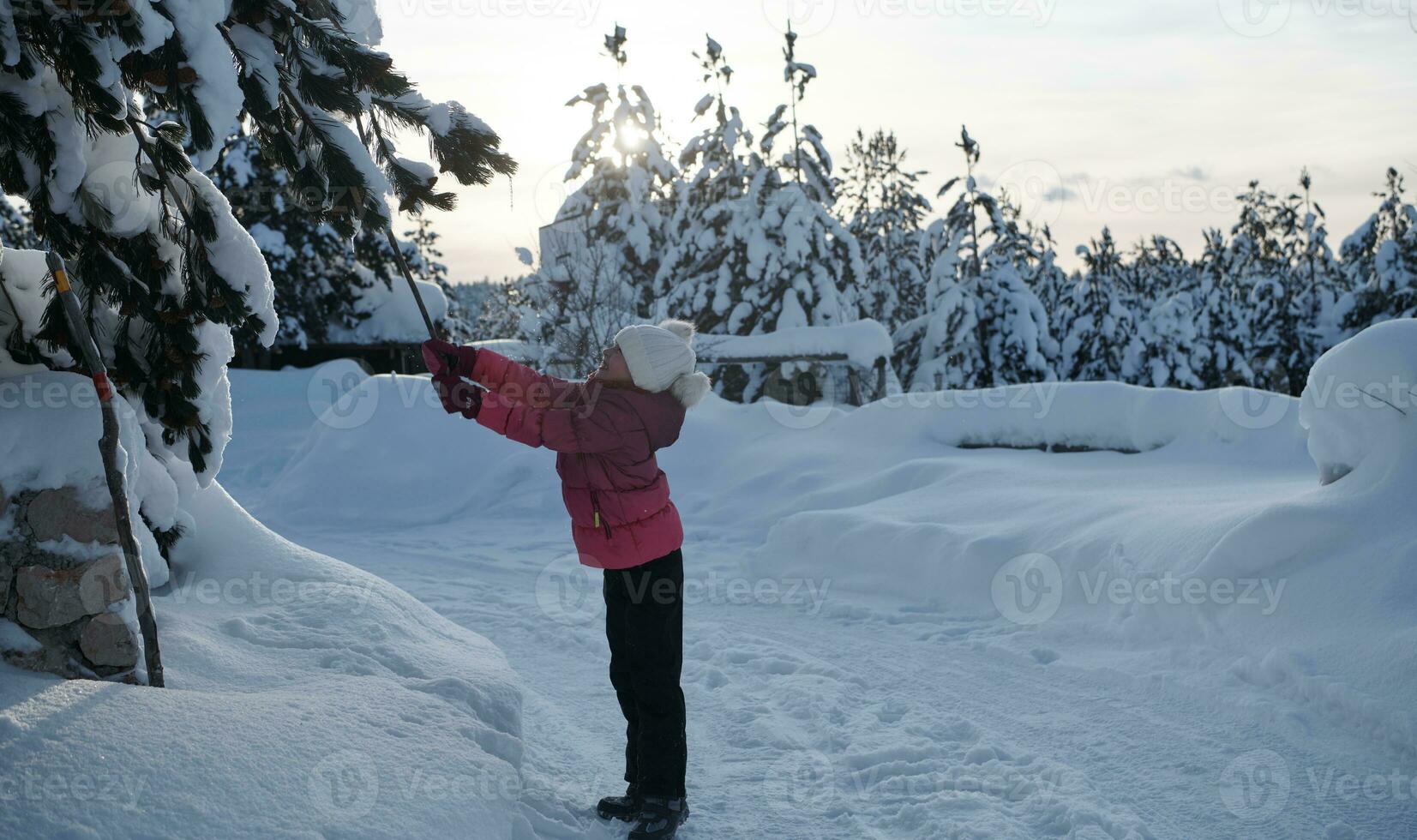 girl throwing fresh snow at beautiful sunny winter day photo