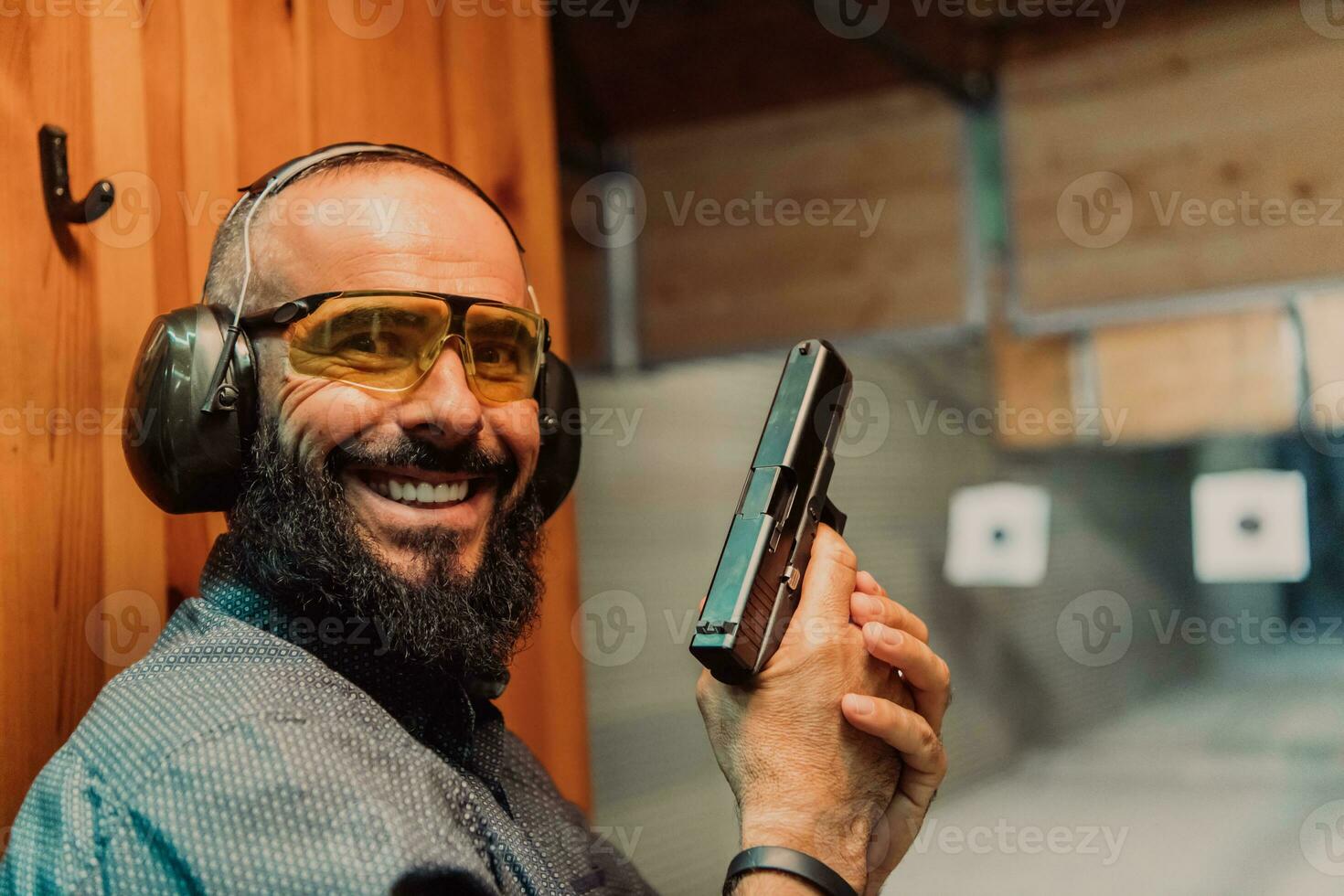 un hombre practicas disparo un pistola en un disparo rango mientras vistiendo protector auriculares foto