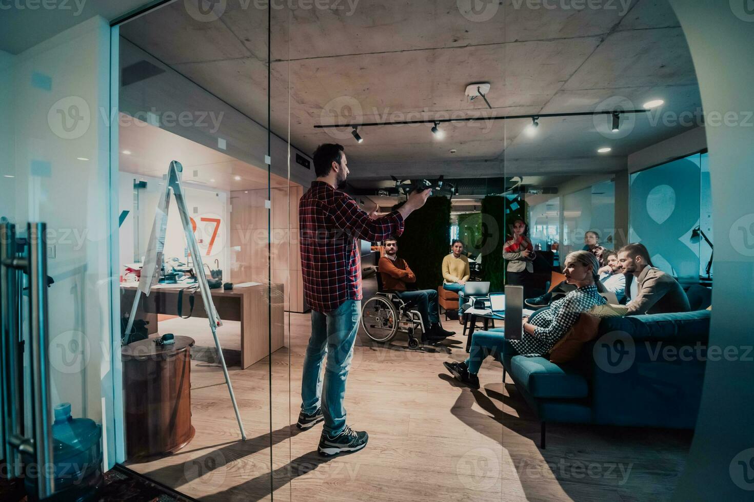 un barbado hombre en un moderno oficina explicando a su joven diverso equipo cómo un zumbido trabajando foto