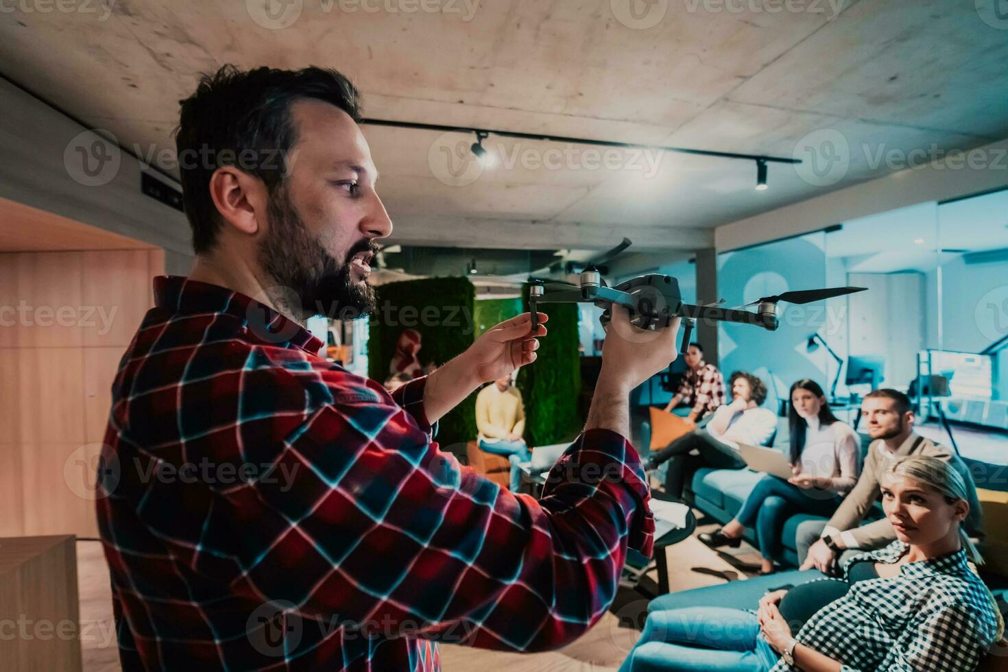 un barbado hombre en un moderno oficina explicando a su joven diverso equipo cómo un zumbido trabajando foto