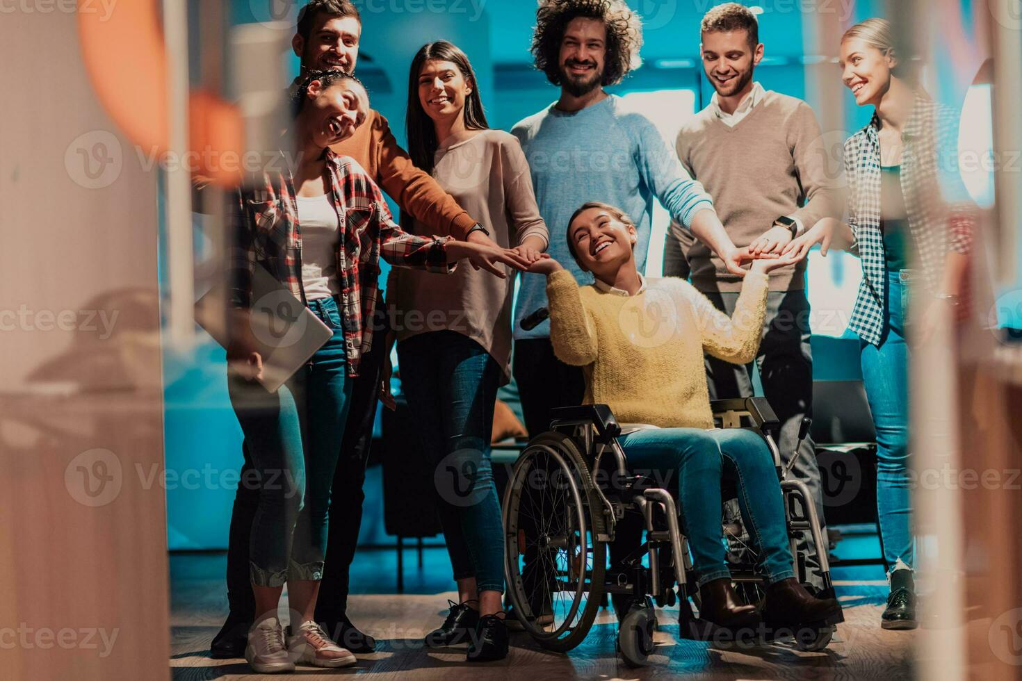 mujer de negocios en un silla de ruedas en descanso en un moderno oficina con su equipo en el antecedentes foto