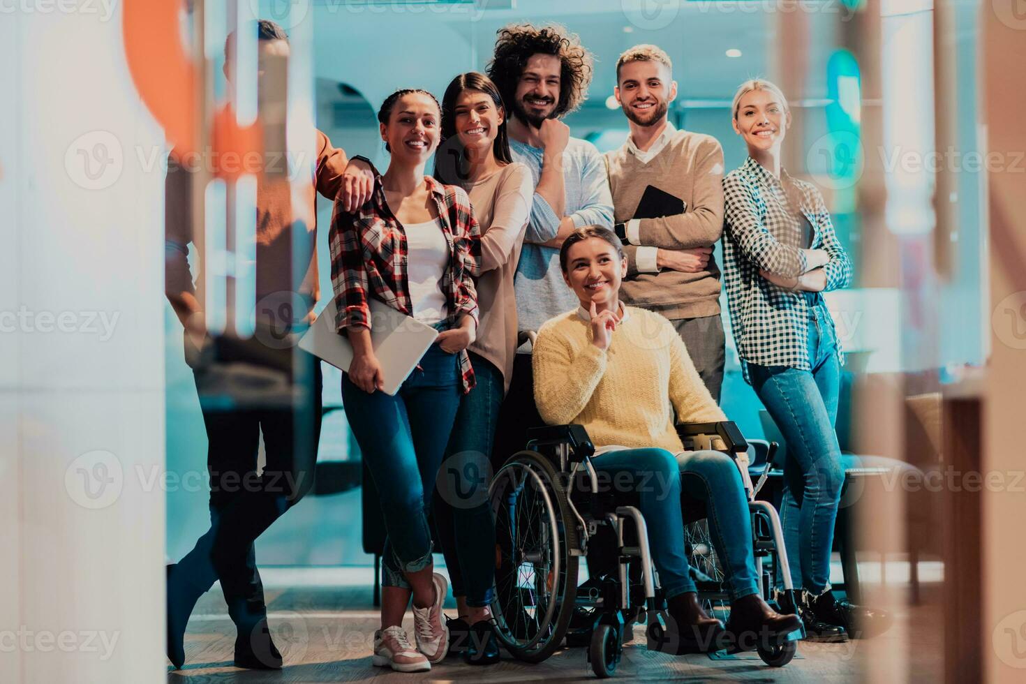 mujer de negocios en un silla de ruedas en descanso en un moderno oficina con su equipo en el antecedentes foto