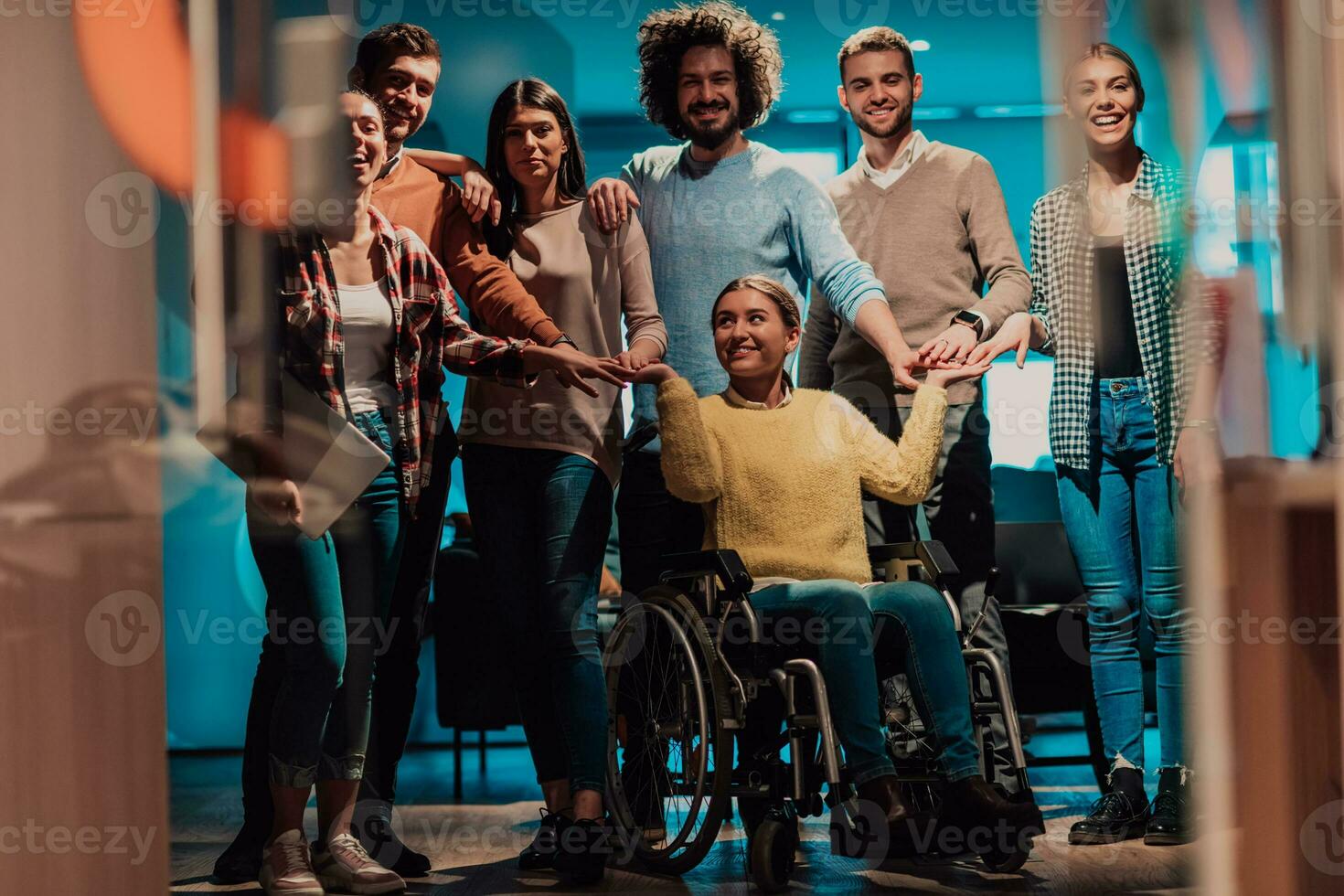 mujer de negocios en un silla de ruedas en descanso en un moderno oficina con su equipo en el antecedentes foto