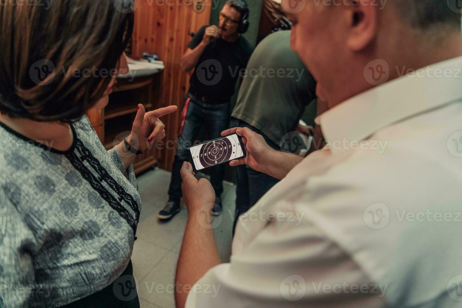 A man in a shooting range takes a picture and examines the results after shooting photo